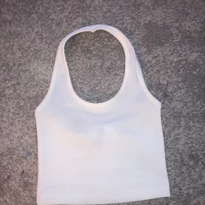 Top - Söt topp ifrån H&M. Likadan som den beiga som jag också säljer. Köpt förra sommaren och är aldrig använd. Den är vit och går runt halsen, öppen rygg och perfekt till sommaren. Storlek Xs