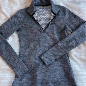 Nike träningströja - Nike träningströja från deras golfkollektion. Väldigt skönt material med halv Zip och hål för tummarna. Nike loggan på vänster arm. Väldigt sparsamt använd. Storlek S men hade funkat som XS också!