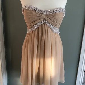 Nude kort klänning stl 36 - Nude kort klänning stl 36 från Nelly. Aldrig använd bara provad. Klänningen är i chiffong och smyckad med vita pärlor i pärlemor. 💕🤩
