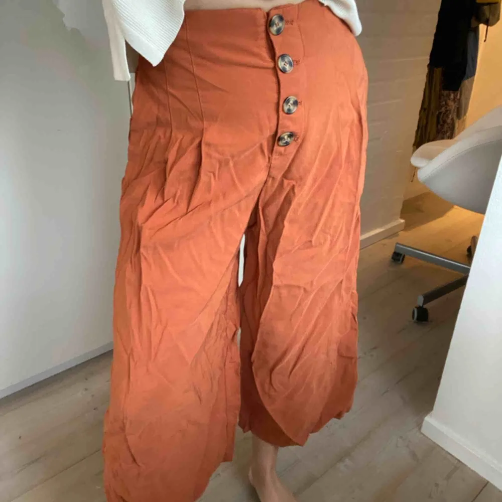 Vida orangea byxor från Zara med brunspräckliga knappar framtill. Lite kortare än vanliga byxor. Använda endast en gång. Säljer pga av att de inte kommer till användning. Frakt tillkommer.💕💕💕💕💕. Jeans & Byxor.