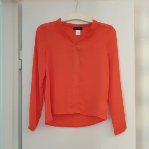  - Jättefin vävd blus i snyggaste färgen orange. Subtilt, men snygga, glittertrådar i v-ringningen och nedåt framtill. I handlar i Frankrike. Aldrig använd. Kommer från djur- och rökfritt hem.  Köparen står för frakten (c:a 42 SEK)