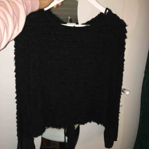  - En svart fin tröja med öppen slits i ryggen