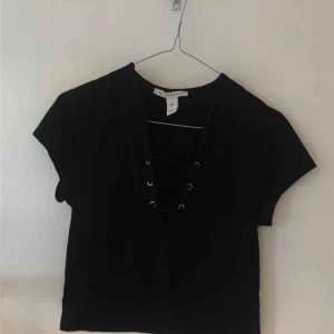  - Svart topp med snörning från NLY trend. Sparsamt använd. Skriv för bättre/ närmre bild på någon detalj etc