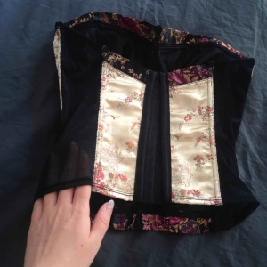  - Lyxig Bustier/korsett, topp i asiatisk stil! Sånt jäkla häftigt plagg! Prickig spets i sidorna och knäpps med bh-hyskor baktill, se bild. Frakt blir ca 27kr