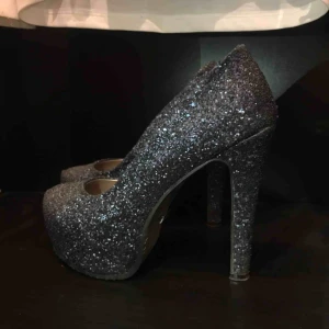  - Superfina mörkblå glittriga pumps från Tiamo, ganska dyra i nypris och inte mycket använda. Strl 39. Kan skickas med spårbar frakt med postnord (63kr) eller mötas i Karlstad med omnejd. 🌸 Skickar alltid med videobevis/bildbevis.