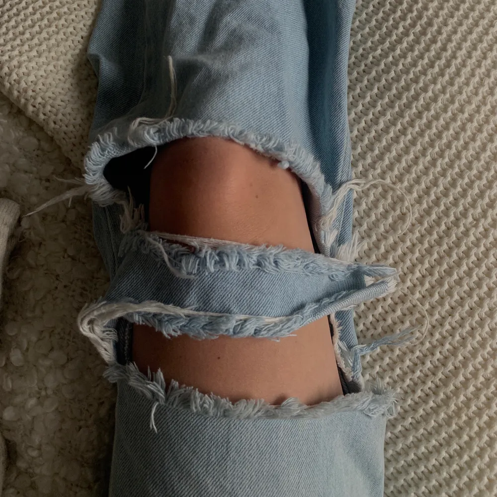 Ett par as snygga ljusblåa jeans med hål på knäna. De är från junkyard med har gjort hålen själv. På vänstra benet är en som en liten bit som hänger ”löst”, man kan klippa bort den om man vill men jag tycker det tillför en schyst detalj. Köpare står för frakt.. Jeans & Byxor.