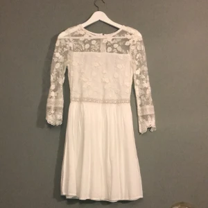 Student/Midsommar klänningsdröm - Vit spets drömklänning! Framhäver figuren, är inte genomskinlig. Spetsdetaljer som visar hud. Dragkedja baktill, figursydd, knälång. Köpare betalar frakt.