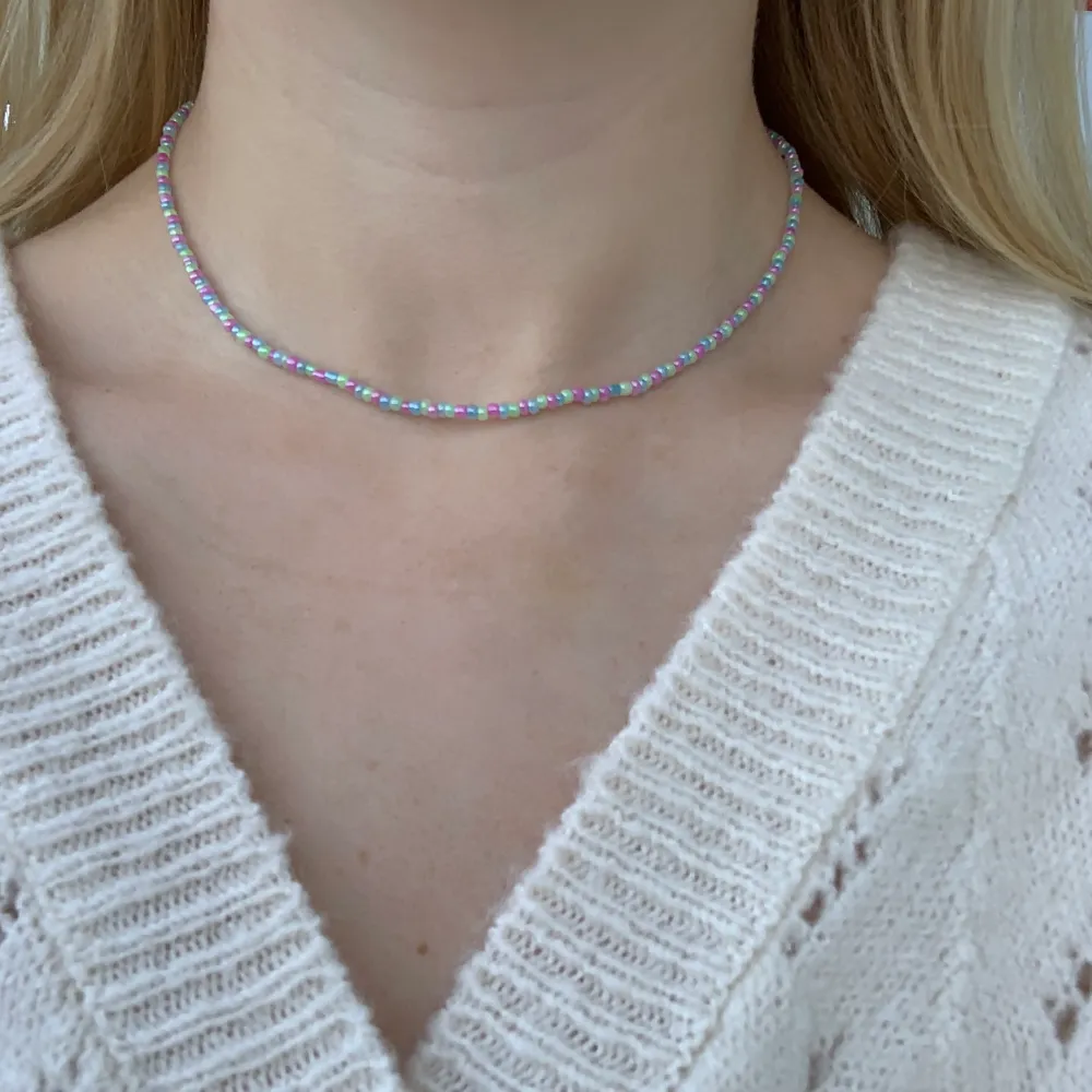 Flerfärgat pärlhalsband med små pärlor🦋💚💕💙🍭💞🍬 halsbandet försluts med lås och tråden är elastisk . Accessoarer.