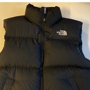North face M Nuptse Väst 1996 - Säljer nu min väst från The North face, köpt för 2199kr hos Sneakerspoint. Köptes 2020-12-04. Använd mycket sparsamt och max 10 gånger. Säljes på grund av att jag köpt en ny väst.  Sjukt stilren väst som passar till allt. Frakt tillkommer! Det är bara att buda!:) 