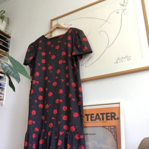  - Tunn sommarklänning. Marinblå med vallmo och vita prickar på. Volang i kjolen. Når till halva vaden på någon som är 170 cm lång. 