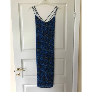  - Fin blåmönstrad semi-lång klänning från Weekday. Väldigt fin öppen rygg med kors av tunna band. Endast använd ett fåtal gånger.
