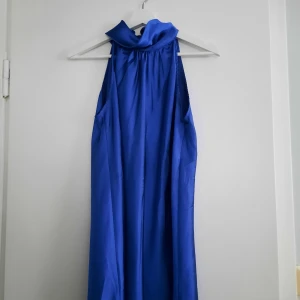 Kort kornblå klännin - 💫 Kornblå klänning i "silke", kortare modell med halterneck. Strlk m men passar även s (mittenstorlek).