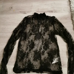 Bikbok spets-blus - Genomskinlig spetsblus med hög hals och knappar i ryggen. Aldrig använd! 