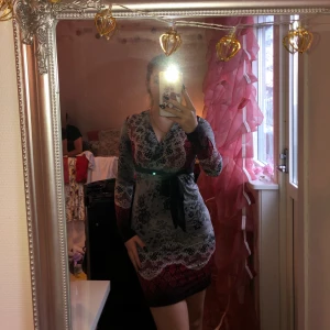 Klänning - Jag säljer klänning som är lite svart/röd/vit. På baksida så är det svarta detaljer som är genomskinliga. Jag är 165cm lång. (Priset kan diskuteras)