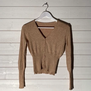 Glittrig topp - Storlek: XS Färg: beige/guld/glitter Frakt: 42kr (möts upp i Falun) Fler bilder? Kontakta oss! 