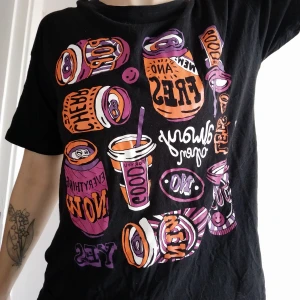 Monki t-shirt - T-shirt från Monki, svart med orange och lila print.