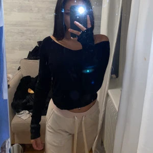 Svart långärmad tröja  - Svart långärmad tröja med urringning fram och bak. Storlek S (väldigt stretchig)