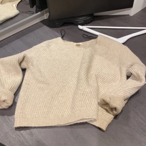 Beige stickad tröja  - Beige stickad tröja med V-ringning. Från H&M i storleken XS. 