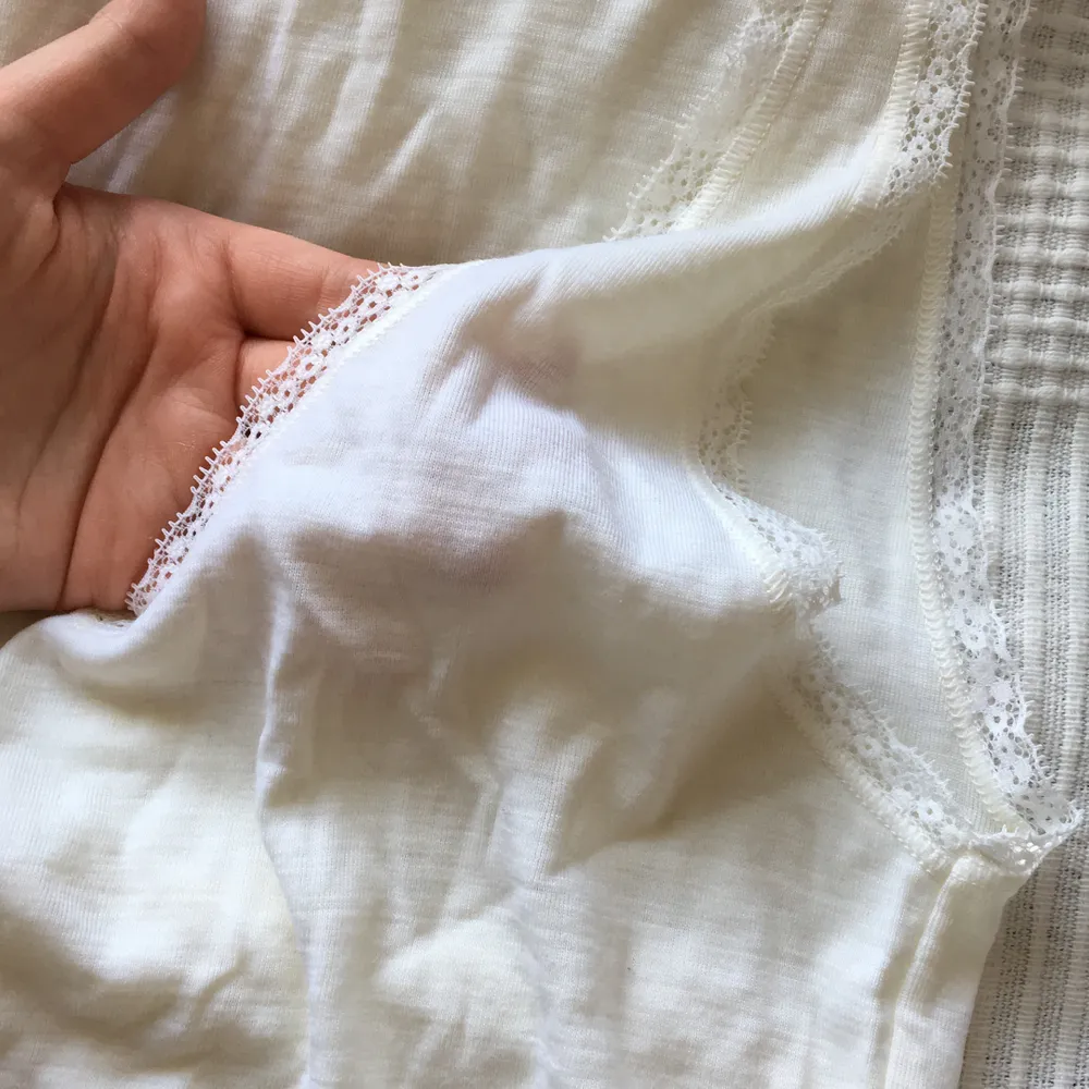 Jättegulligt linne i ull som är supermysigt nu till hösten, i en mer cremevit färg och med spets på kanterna. V ringat. Knappt genomskinligt och använt typ 2 gånger innan det blev för litet, storlek M. Yläosat.