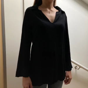 Svart blus  - Fin blus med krage och liten slit på sidorna. Superskönt material, strl S. Har använts men är i gott skick, tyget blir inte nopprigt. 