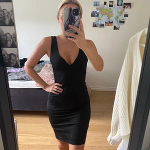 Svart fodralklänning i storlek XS - Tight svart fodralklänning med djup ringning fram och bak. Köpt från Nelly.com i storlek XS. Använd 1 gång, frakt ingår i priset!