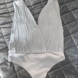 Body från Bik Bok - Snygg festbody från Bik Bok. Den ser likadan ut fram som bak så den är öppen en bit på båda sidorna! Bra material nertill så man kan ha den under allt, blir ingen troskant! Kan skicka mer bilder om så önskas! 