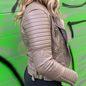 Tessie skinnjacka  - Beigegrön jacka från nellie Berntssons märke tessie. Det står strl 42 men är väldigt liten i storlek så den passar perfekt för en S