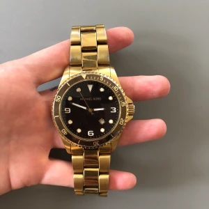 Klocka mk-7058 - Klocka från Michael kors, modell 7058. Slutsåld. Herrmodell men har haft själv för en maffigare look. Liten repa i glas runt uret mellan ”20-30” i nedre högra hörn. Behöver nya batterier. 