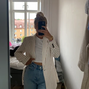 Kavaj storlek 38  - Gräddvit med biege/bruna ränder. 50% cotton & 50% shell. Riktigt sval och skön att ha nu under sommarkvällar! 