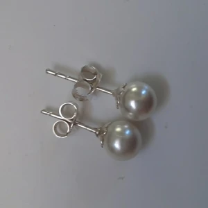 Örhängen vita pärlor - Ca 5 mm i diameter. Frakt 12 kr. Se min profil för fler smycken. 