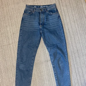 Mom jeans  - Mom jeans från Never Denim, färgen stone wash. 100% bomull. Använda fåtal gånger, super fint skick! Inköpta förra året för 499kr. Säljer för 200kr + frakt! Kan sänka priset vid snabb affär!