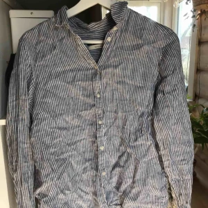  - Fin blå och vit randig skjorta i linne, som inte kommer till användning.   Köparen står för frakt (: