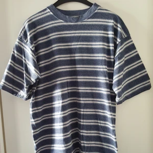  - Vintage randig t-shirt. Har ett litet hål nere framtill (se bild 2). Kan skickas om köparen står för frakten.