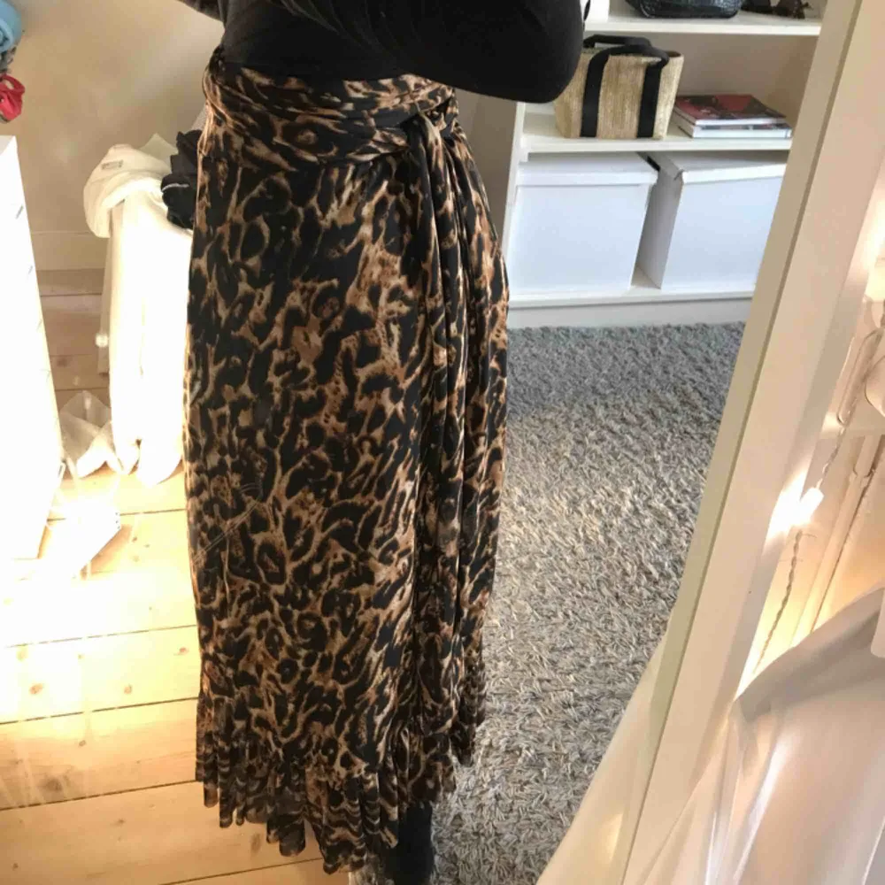 En fin leopardkjol från NA-KD. Storlek XS men passar högre storlekar också då man knyter midjan med ett band. Använd ett få antal gånger i somras så i jättefint skick! Köparen står för frakten🖤. Kjolar.