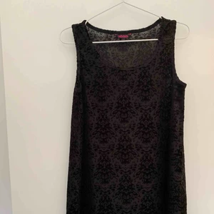  - Svart kort klänning, A-linjeformad med sammetsmönster.   Köparen står för porto. 