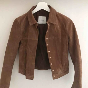  - En skitsnygg jacka i brun mockaimitation! I nyskick då jag aldrig hann att använda den mer än ett fåtal gånger innan jag växte ur den :( Går också att använda som ”skjorta” om man stänger den som visat på andra bilden :)