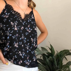  - Svart fin blommig blus med spetsdetaljer Passar alla storlekar. 25kr