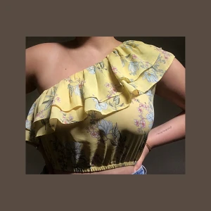 Oneshoulder topp blommigt mönster S - Fin somrig enaxlad croptop med volang. 🌻 Går att ha utan Bh utan att det syns, bra skick. Jag bjuder på frakten 🥰