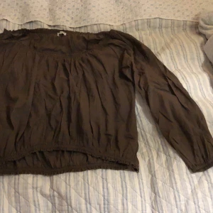 Brun blus - En brun blus från hunkydory med resår längs alla kanter. Passar som en L/XL.