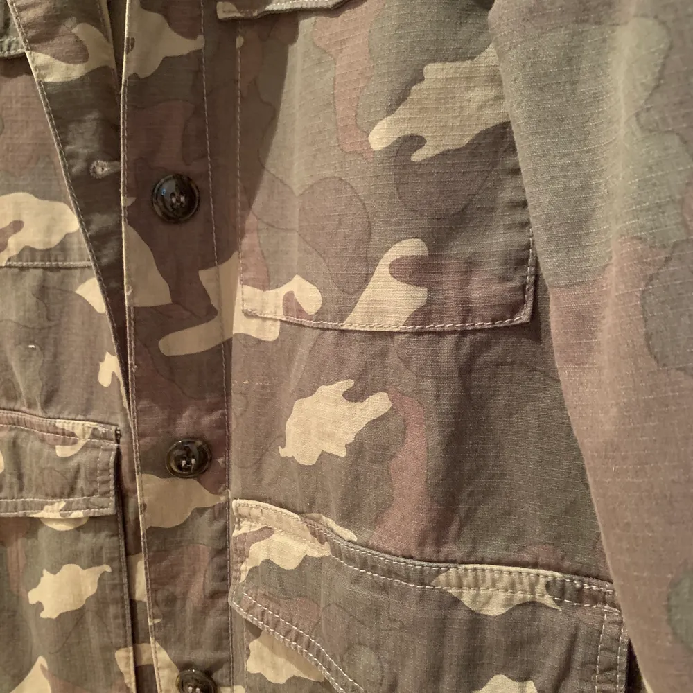 Tunn camouflage jacka från HM i storleken 36. Jackan har många fickor och stängs med knappar. Använd enstaka gånger och är i mycket bra skick.. Jackor.