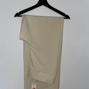 Helt ny beige byxor i storlek L - Helt nya vidbenta beige byxor i Storlek L från Gina tricot  , är i helt nytt skick, prislapp fortfarande på, är ett par månader gammal. Och är mycket stretchig.
