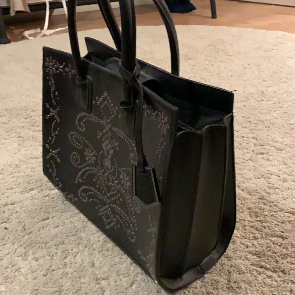 En svart skit snygg väska, aldrig använd.                Pris kan diskuteras. Väskor.
