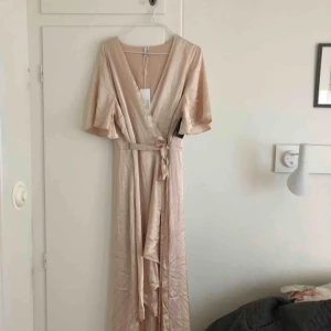  - Satin Wrap Dress, från Nelly. Färgen heter Champange men går mer åt det rosa hållet. Kortare framtill, längre bak! Aldrig använd!