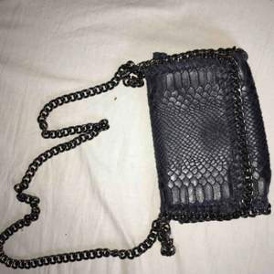 Liten väska med mörkblå ormskinns imitation med kedjeband