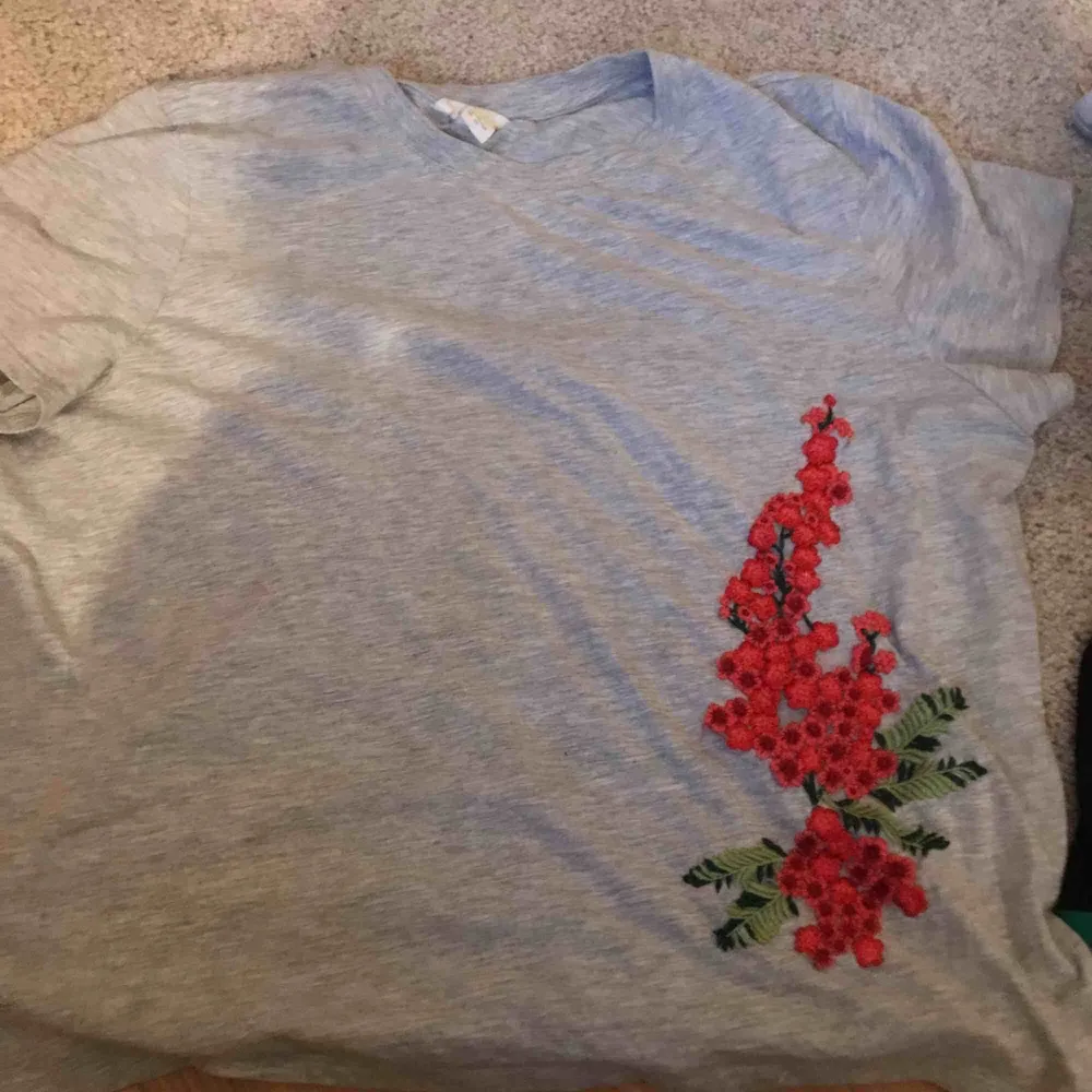 En grå over size t-shirt med blommor tryck på sidan. T-shirts.
