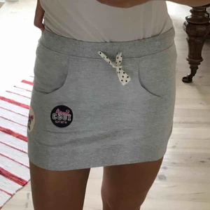  - Kort grå mjukiskjol med fick och små söta detaljer. Knappt använd!👍