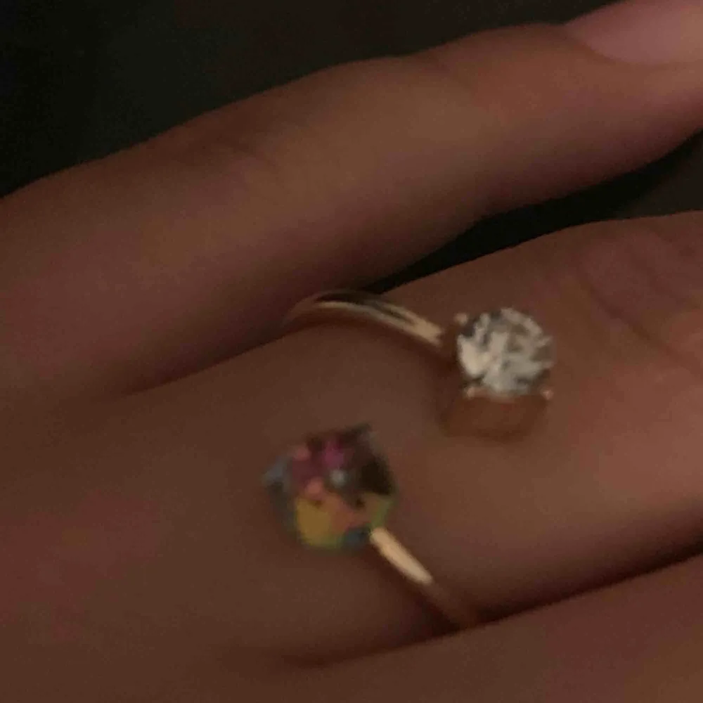Cool ring i guldfärg med två stenar i. En silver och en ”regnbåge”. Storleken går att bestämma lite själv då man kan göra avståndet mellan stenarna större eller mindre!. Accessoarer.