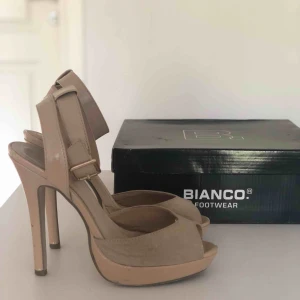  - Beige sandal med hög klack. Lite slitna, se bilder. Orginalkartong följer med. Hämtas i Malmö eller skickas mot frakt. 