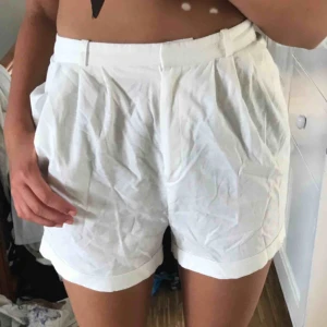  - Vita puffiga shorts, sitter åt i midjan. 