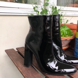 ankelboots med klack - svarta ankelboots i vinyl. utmärkt skick, endast testade. något elektriska och drar därför åt sig damm (det som syns på sista bilden)